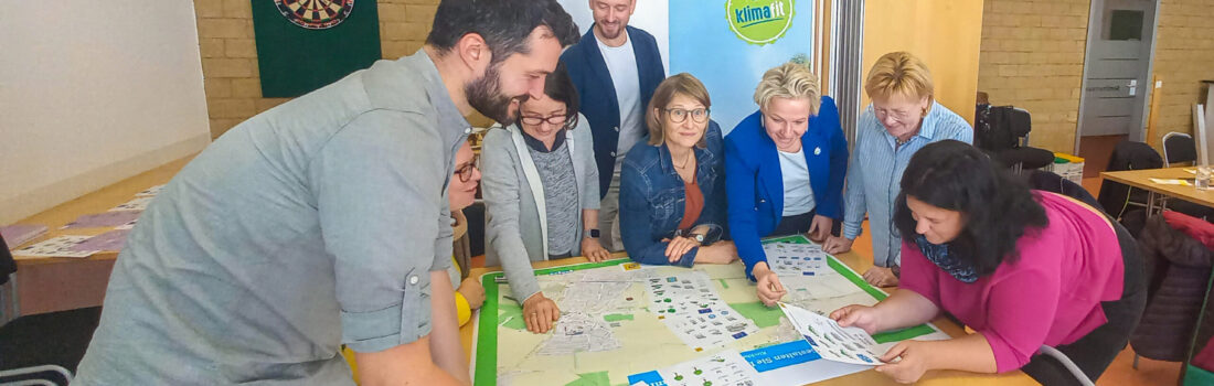 Menschen die zusammen über einem Plakat diskutieren und Notizen machen
