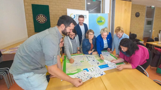 Menschen die zusammen über einem Plakat diskutieren und Notizen machen