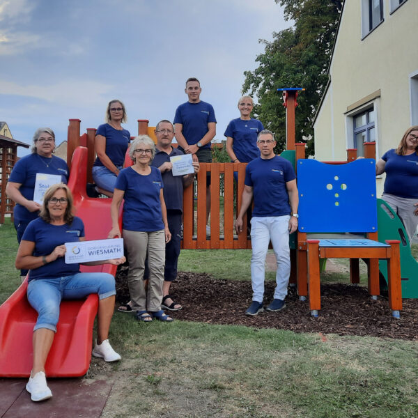 Menschen vor dem Spieleturm am Kinderspielplatz