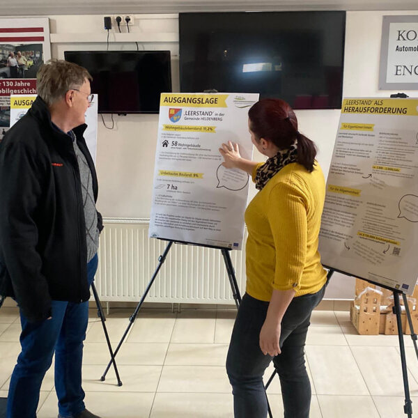 Gespräch zwischen einem Gemeindebürger und Judith Pfeifer bei der Wanderausstellung in Heldenberg.