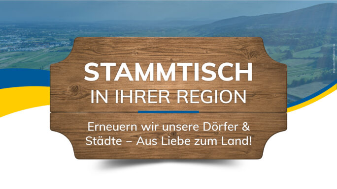 Holzbrett vor blauem hintergrund, der eine Landschaft in NÖ zeigt, mit der Aufschrift Stammtisch in Ihrer Region - Erneuern wir unsere Dörfer und Städte - Aus Liebe zum Land
