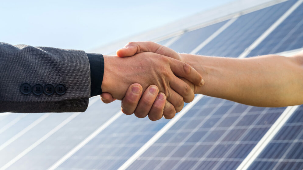 Hände schütteln im Hintergrund PV-Modul
