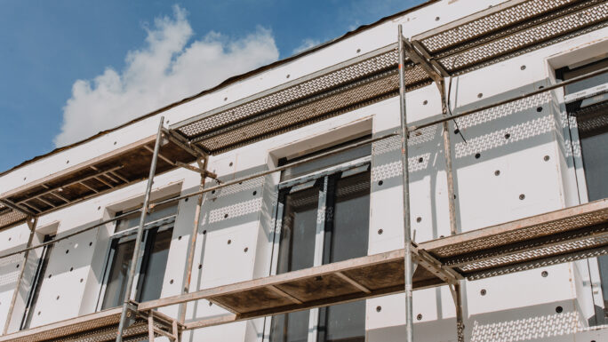 Gerüst an einer Hausfassade, modernes Gebäude im Bau –
