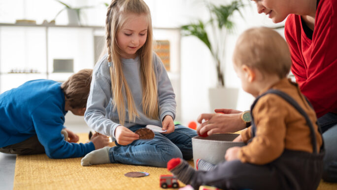 Lehrer, der Kindern beim Spielen zusieht